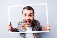35529210-knappe-jonge-man-in-shirt-bedrijf-picture-frame-in-de-voorkant-van-zijn-gezicht-en-gl...jpg
